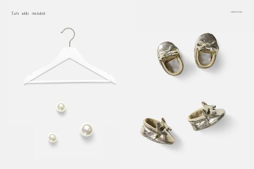 Front view of a baby dress mockup scene featuring a white hanger, metallic baby shoes, and decorative pearls on a light background.