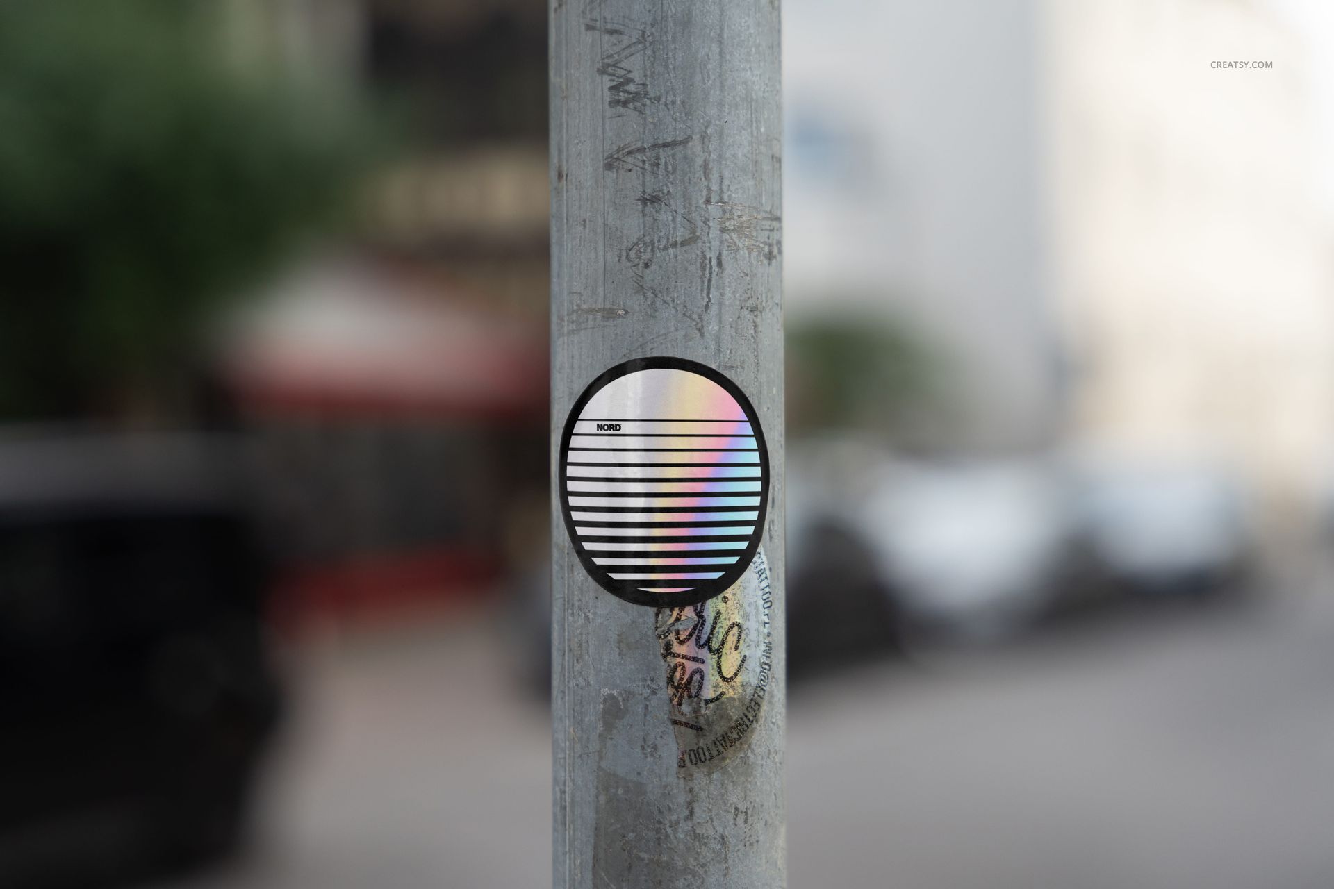 PSD mockup showing a circular sticker with striped design and rainbow colors placed on a vertical metal pole.