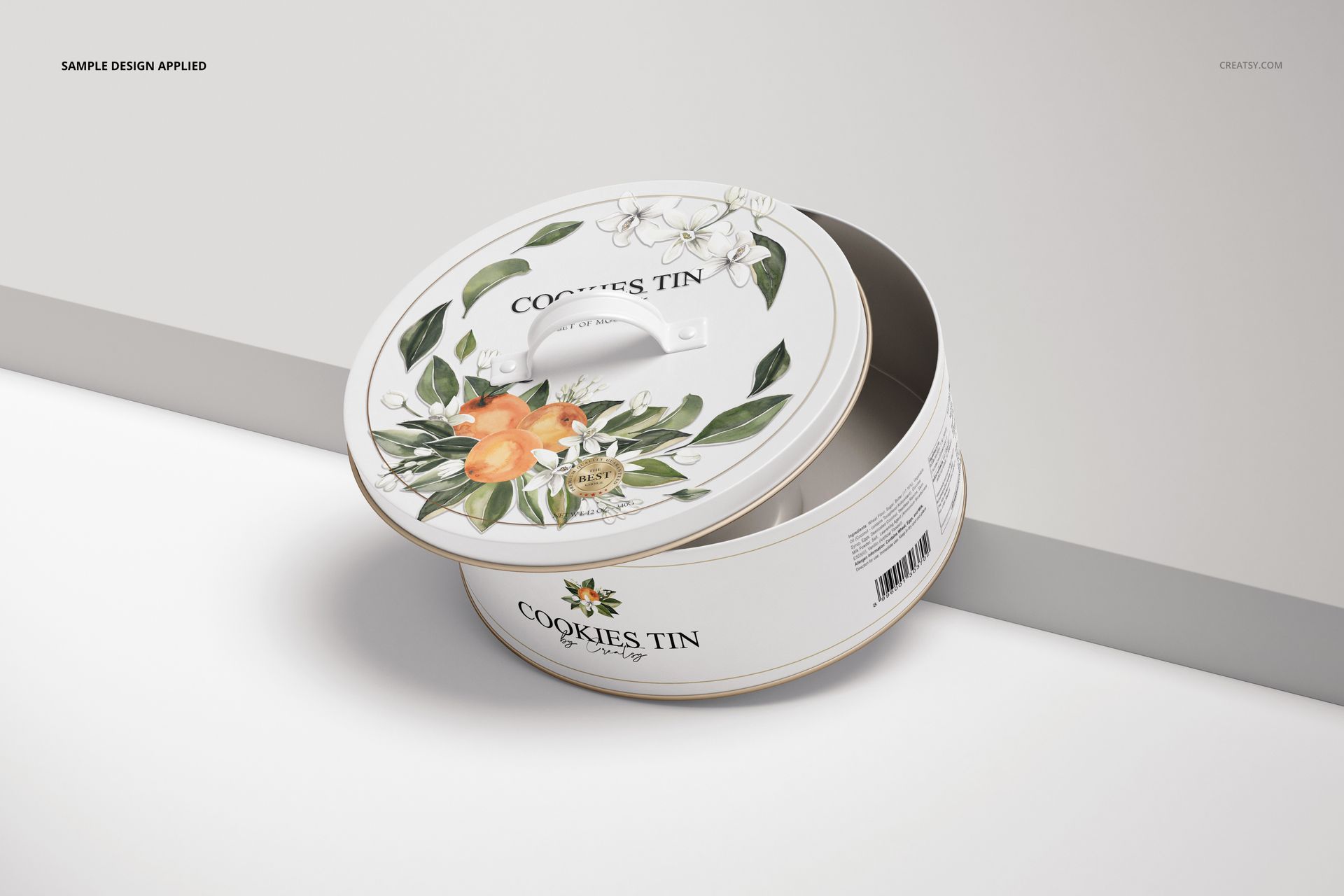PSD mockup of a round cookie tin featuring orange fruits and green leaves, lid slightly lifted to reveal interior.