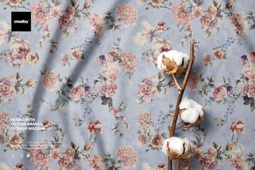PSD mockup of fabric with a delicate flower print and a cotton branch, viewed from above in a detailed scene.
