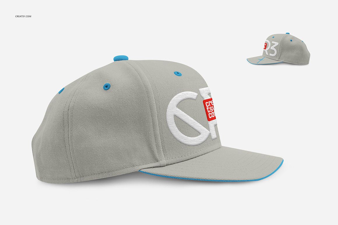 PSD mockup of a gray snapback cap featuring blue eyelets and a white embroidered logo, displayed in side perspective.