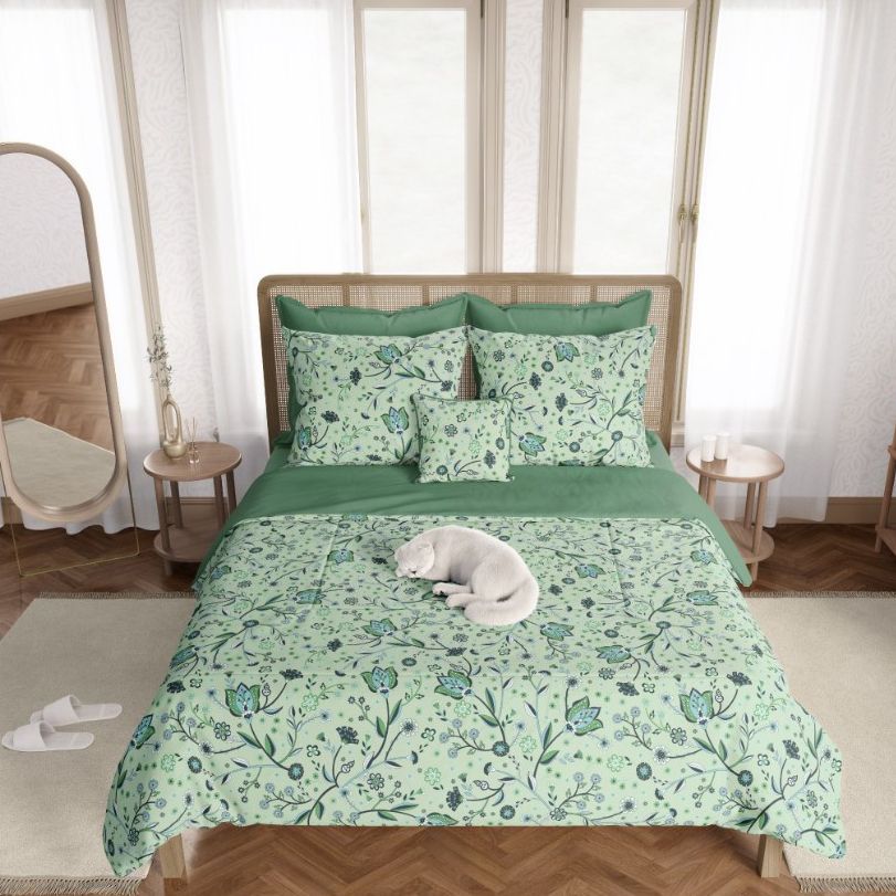 Boho bedroom bedding mockup featuring green floral patterned duvet and pillows on a wooden bed, with a white cat lying on the bed.