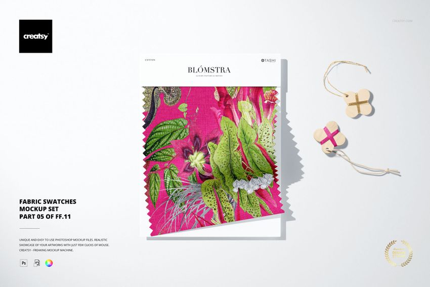 Fabric swatch mockup featuring a colorful floral design, shown alongside small wooden thread winders and a gift box.