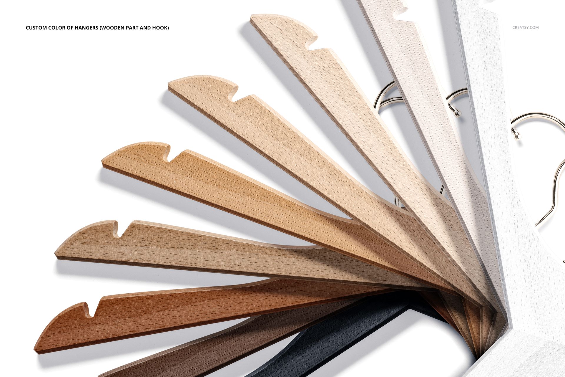 PSD mockup of personalized hangers in assorted wood colors, metal hooks visible, photographed from above on a bright surface.