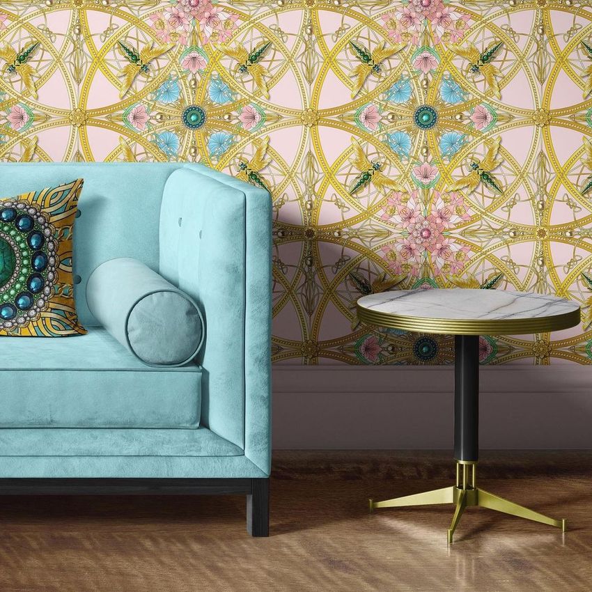 Velvet sofa and coffee table mockup featuring a light blue tufted sofa with a patterned pillow, next to a round marble table on a wooden floor.