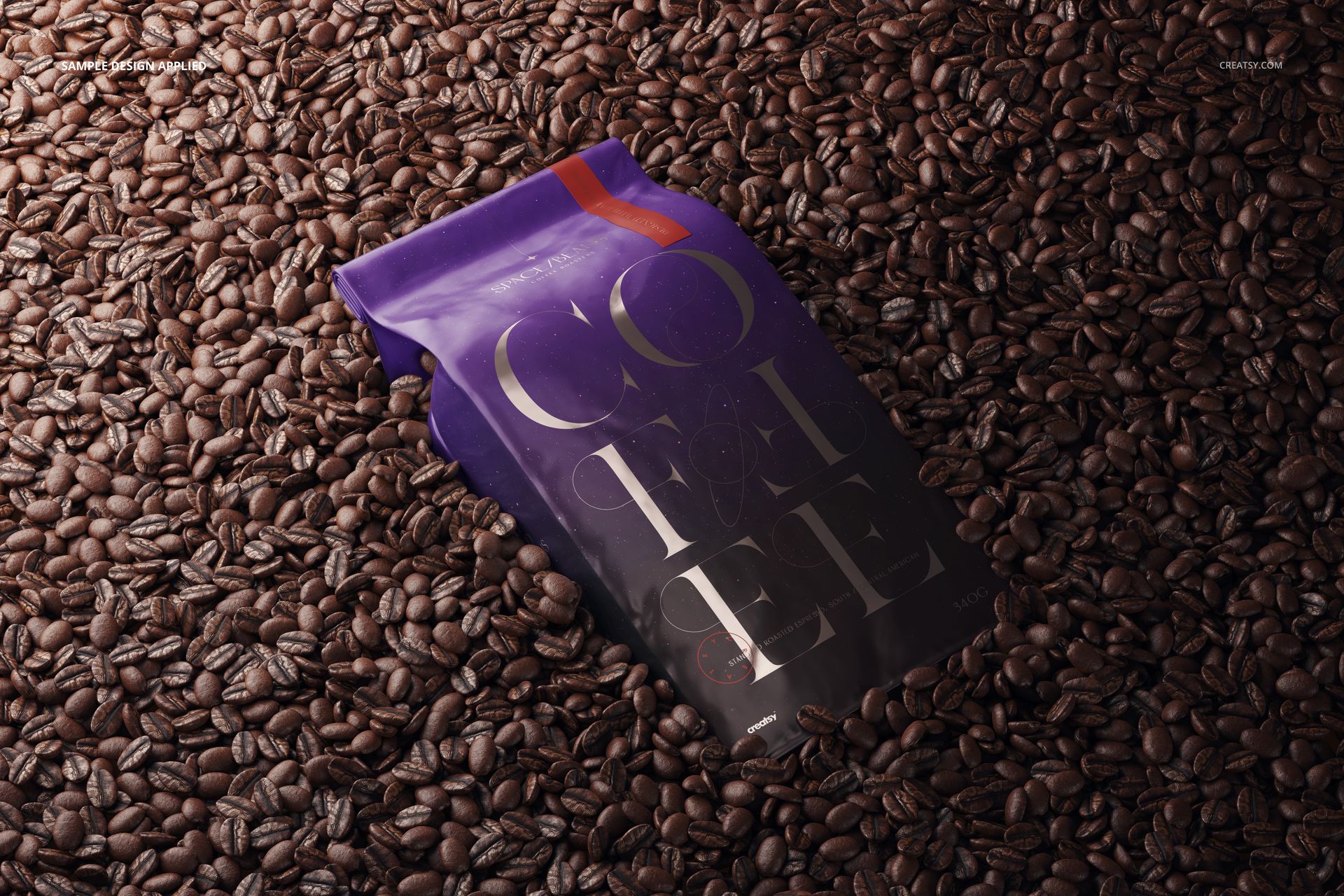 Glossy coffee bag mockup with purple and metallic accents displayed on a surface covered with roasted coffee beans.