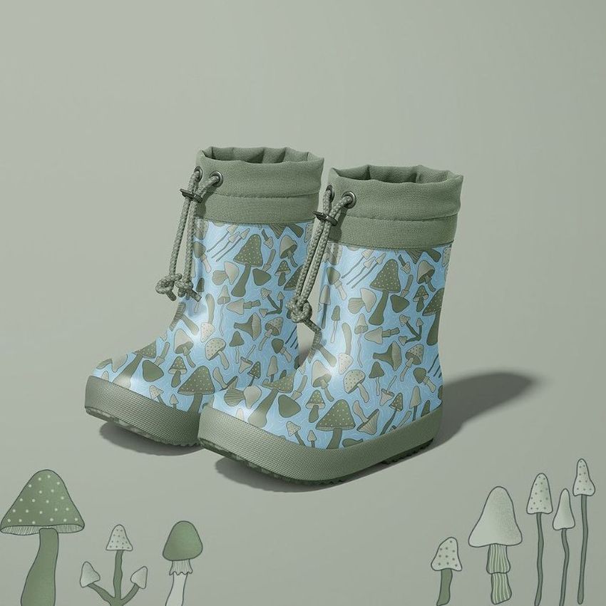 Kids rain boots mockup featuring a pair of boots with a green and blue mushroom pattern, set on a matching illustrated background.