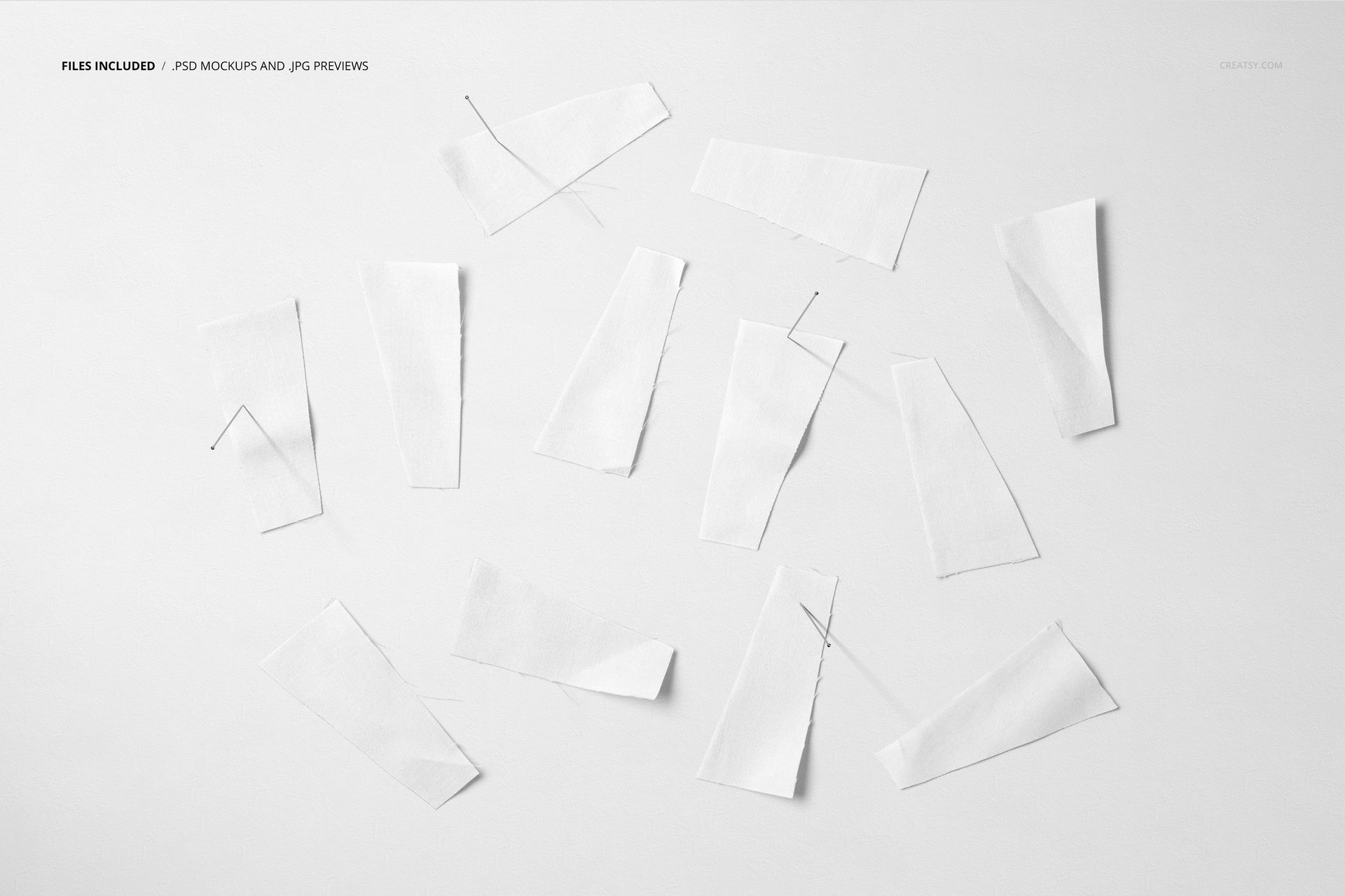 Assorted white fabric pieces arranged on a light background, viewed from above with visible sewing pins.