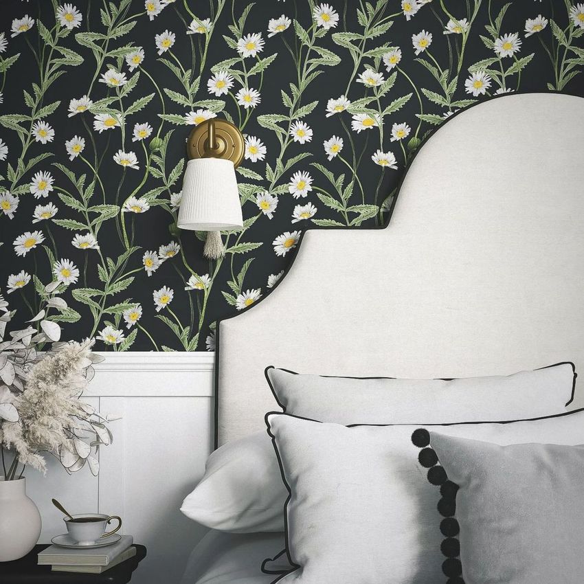 Bedroom mockup with a white upholstered headboard, black and white pillows, and floral daisy wallpaper in the background.
