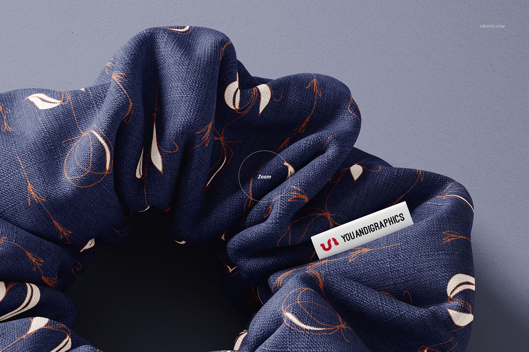 Detailed top view of a fabric hair scrunchie mockup featuring navy blue color and scattered abstract designs.