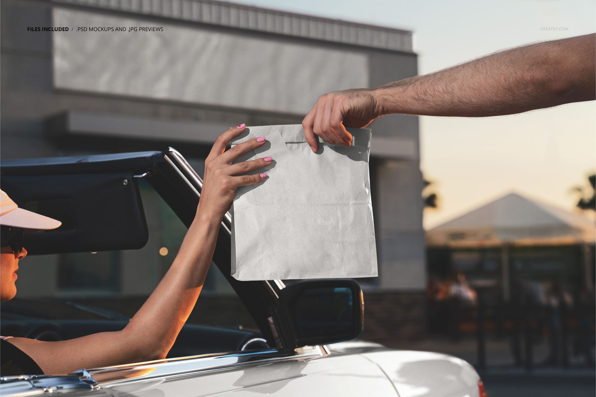 PSD mockup showing a white burger paper bag exchange between two people, one in a car, in front of a restaurant.