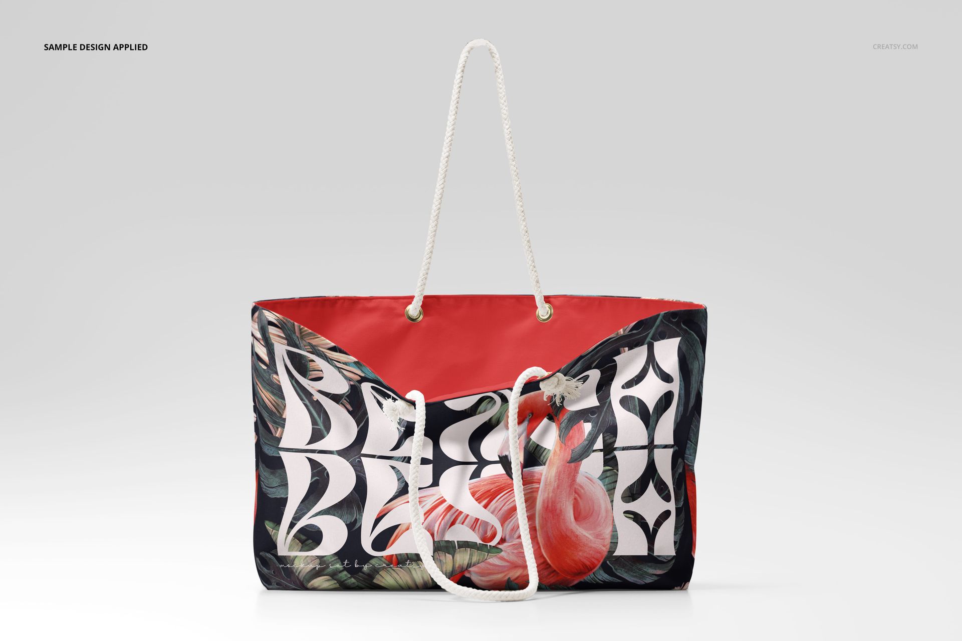 Weekender bag mockup with white rope handles, featuring a flamingo and leaf pattern on a red and black background.