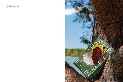 PSD mockup of a packaging box with botanical artwork and prominent text, placed on a tree in a natural setting.