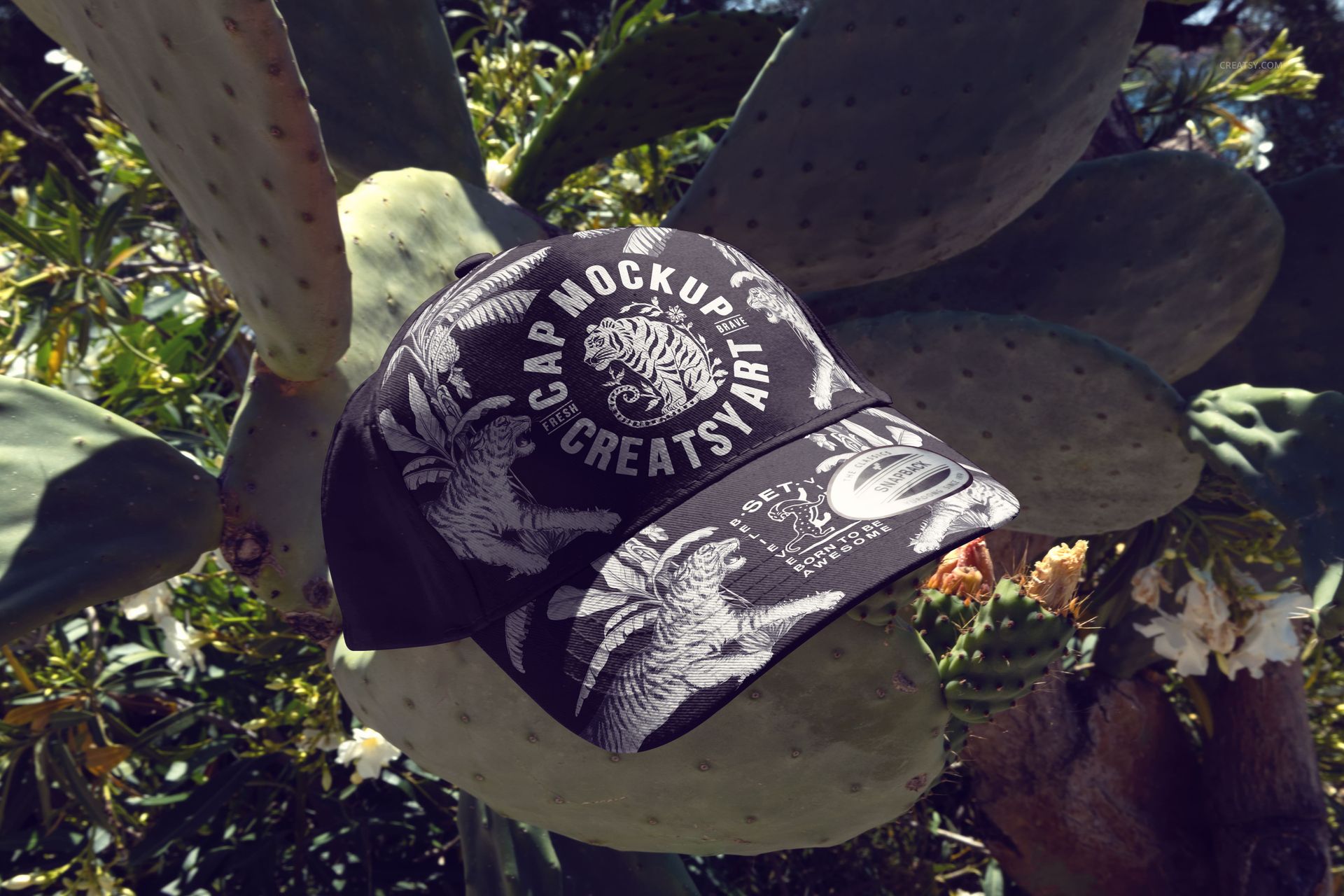 PSD mockup of a classic snapback cap featuring a monochrome pattern, set outdoors among cactus plants and leaves.