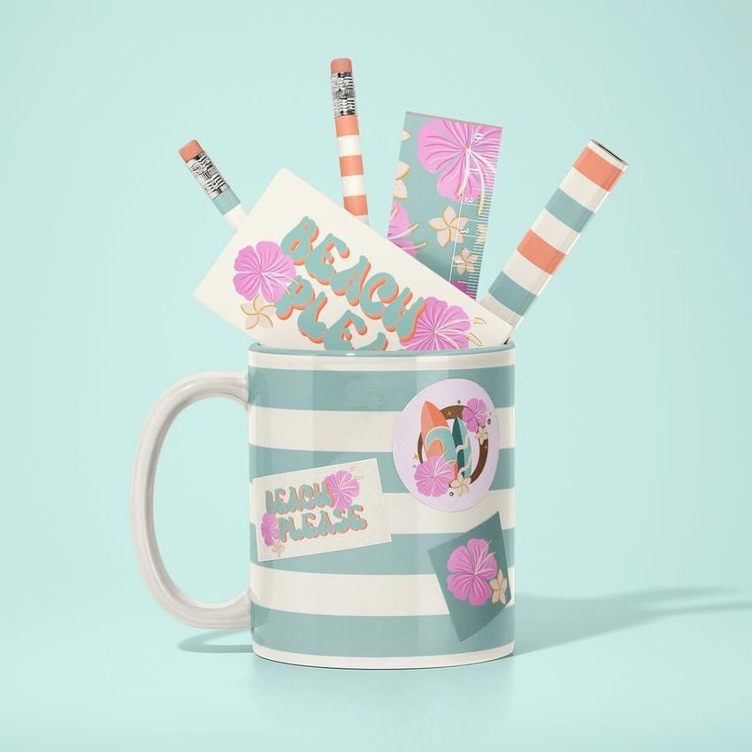 Mug mockup with horizontal teal and white stripes, holding pencils, erasers, and cards with pastel floral designs and text.