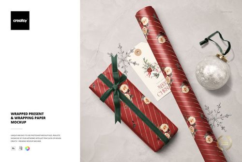 Christmas PSD mockup showing a rectangular present, roll of patterned paper, ornament, and tag arranged on a neutral backdrop.