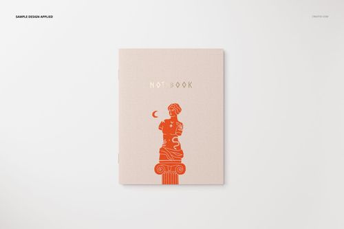 Stationery mockup showing a closed notebook with minimalist artwork and gold lettering, viewed from above on a plain background.