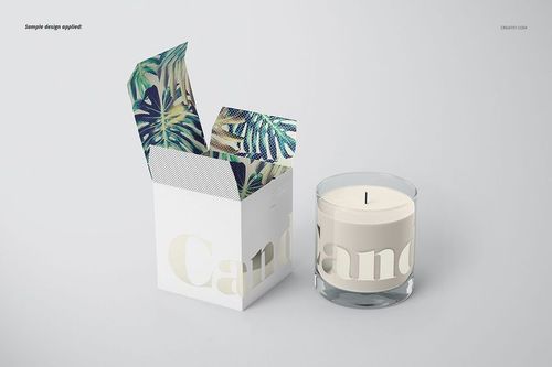 Classic candle mockup showing a round glass candle and a white box with botanical pattern inside, displayed on a plain surface.