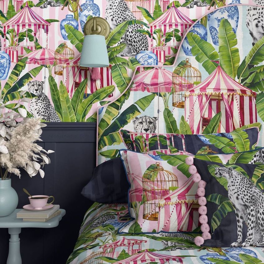 Bedroom pillows, headboard, and wallpaper mockup featuring a bold tropical and animal print with green leaves, pink stripes, and leopards.