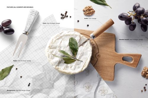 Top view of camembert cheese on a wooden board with a fork, grapes, and wrapping paper mockup elements.