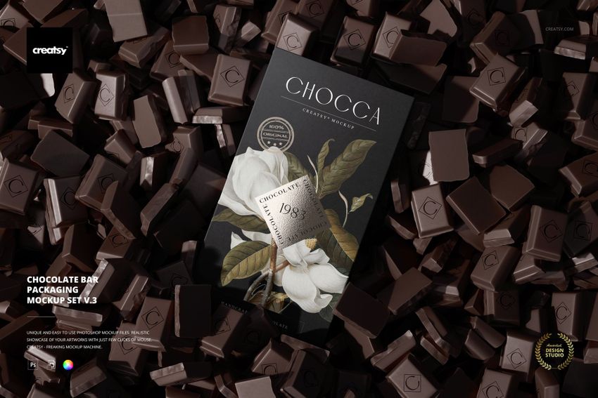 PSD mockup showing a chocolate bar with botanical wrapper design, lying amidst a pile of unwrapped chocolate cubes.
