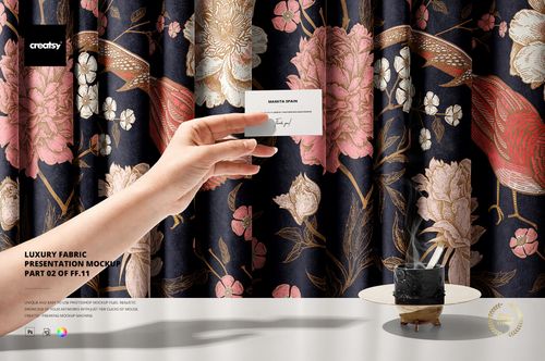 Front view of patterned curtain fabric with pink and beige flowers, birds, and a hand holding a card, PSD mockup style.