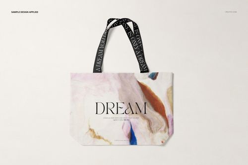 Front view of a shopper canvas bag mockup with abstract pastel patterns and black handles featuring white text.