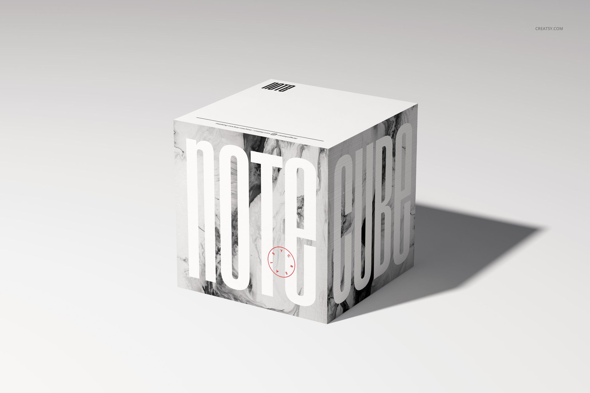 Note cube mockup featuring a cube-shaped stationery item with marble texture and oversized white lettering, front view.
