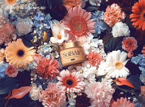 Cream jar with floral label design surrounded by assorted pink and white flowers in a top view studio mockup.