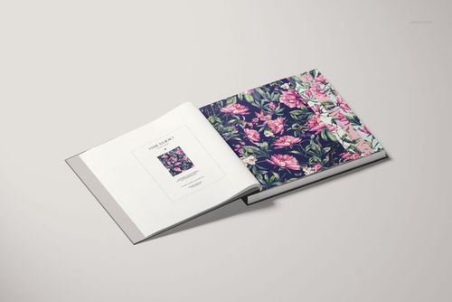 Wallpaper sample book mockup featuring an open spread with vibrant floral designs and a neutral background.