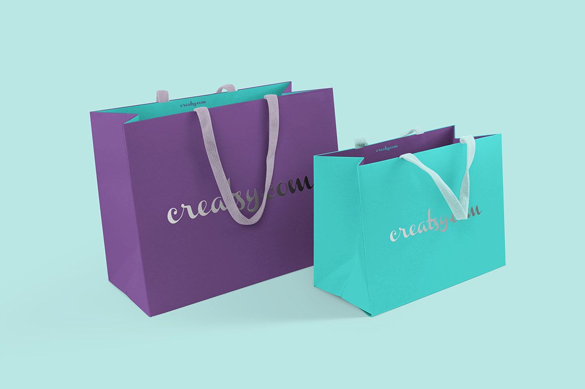 Front view of two colorful paper bags mockup, featuring purple and turquoise bags with white handles and metallic text.