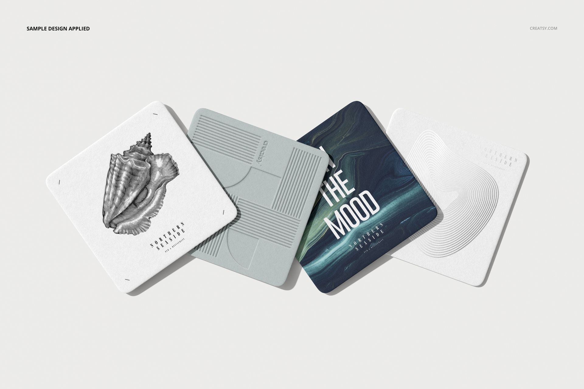 Square coasters PSD mockup showing diverse artwork and textures, laid out side by side on a neutral background.