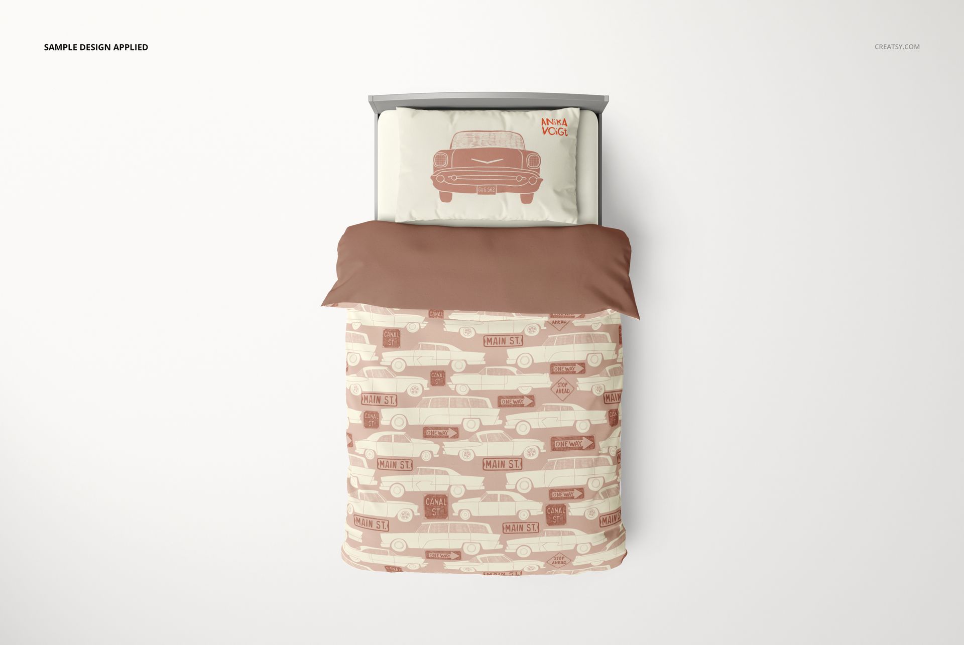 Kids bedding set mockup featuring a top view of a bed with a car-themed pillow and patterned duvet in beige and brown tones.