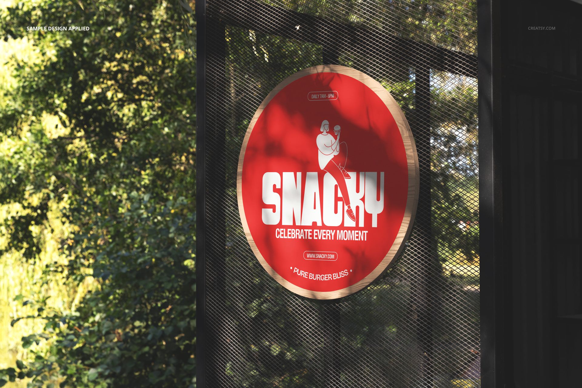 PSD mockup of a circular signboard featuring a red design and white lettering, mounted on a dark mesh structure outdoors.