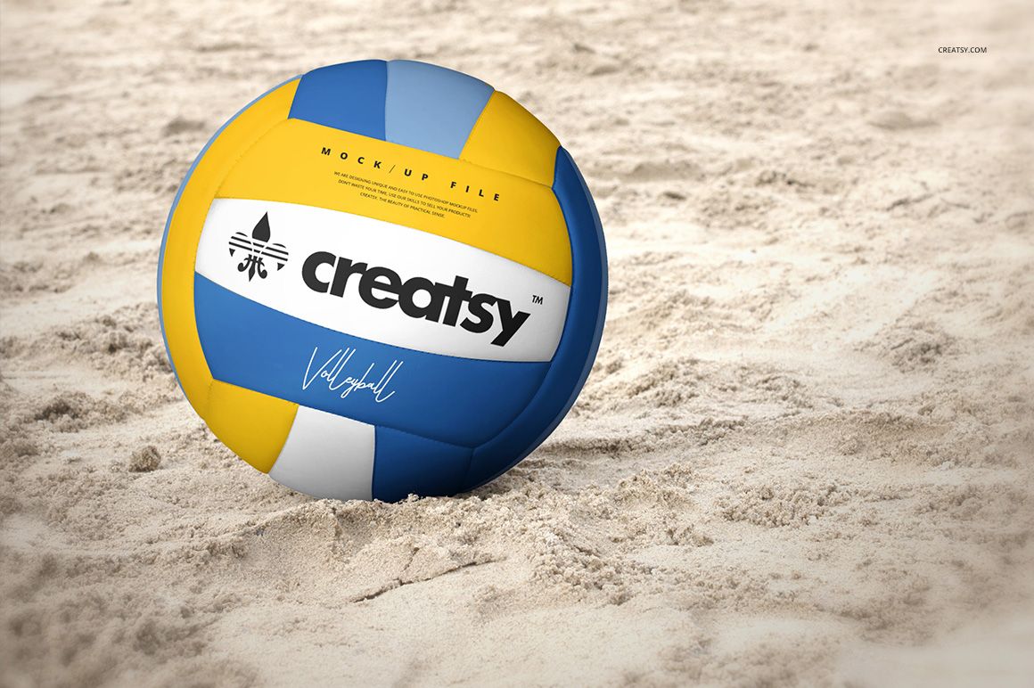 Front-facing volleyball ball mockup with multicolor design and text, positioned on a textured sand surface.