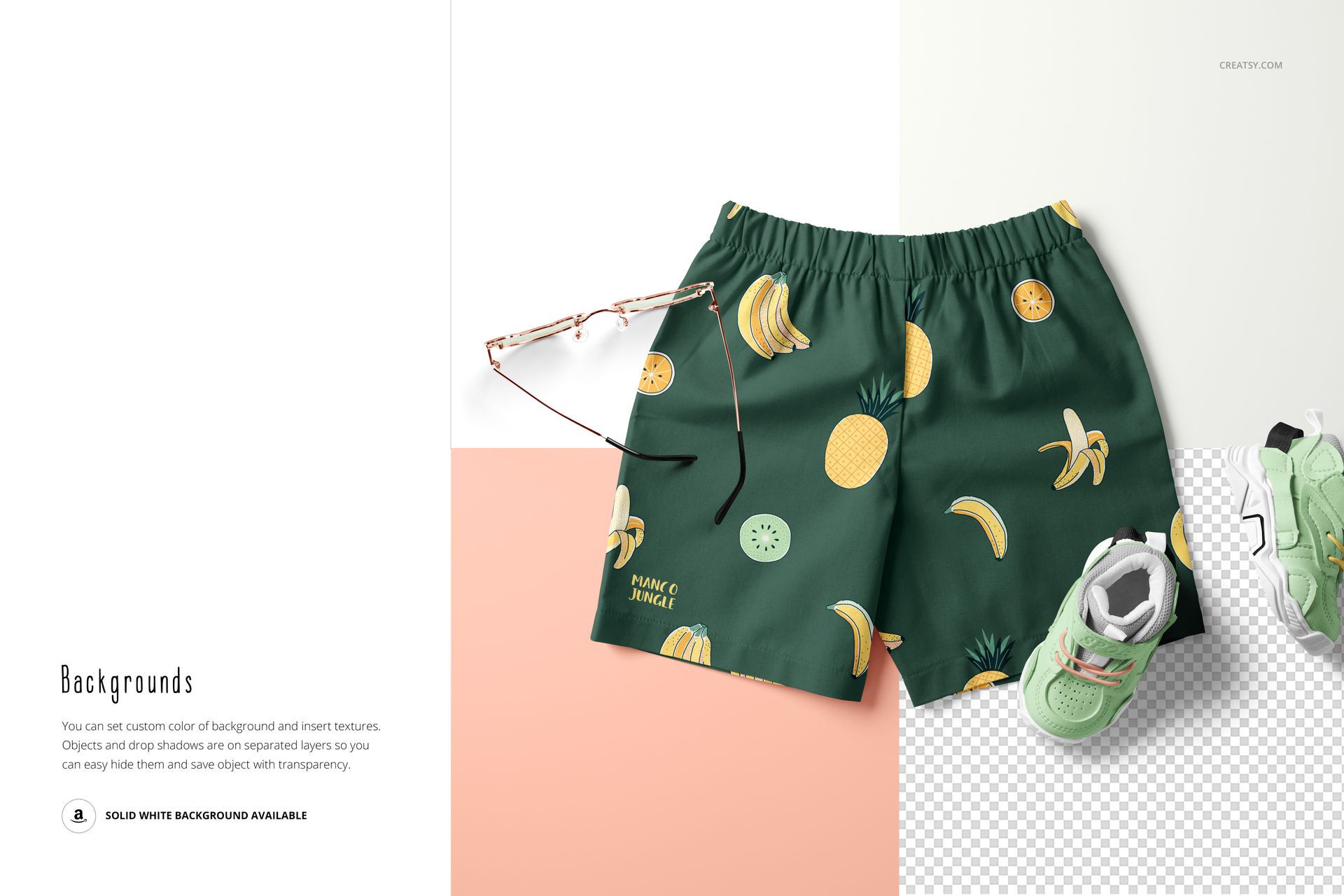 Front view of green kids shorts with banana and pineapple pattern, displayed next to sunglasses and a sneaker on a mockup scene.