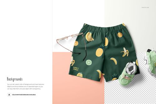 Front view of green kids shorts with banana and pineapple pattern, displayed next to sunglasses and a sneaker on a mockup scene.