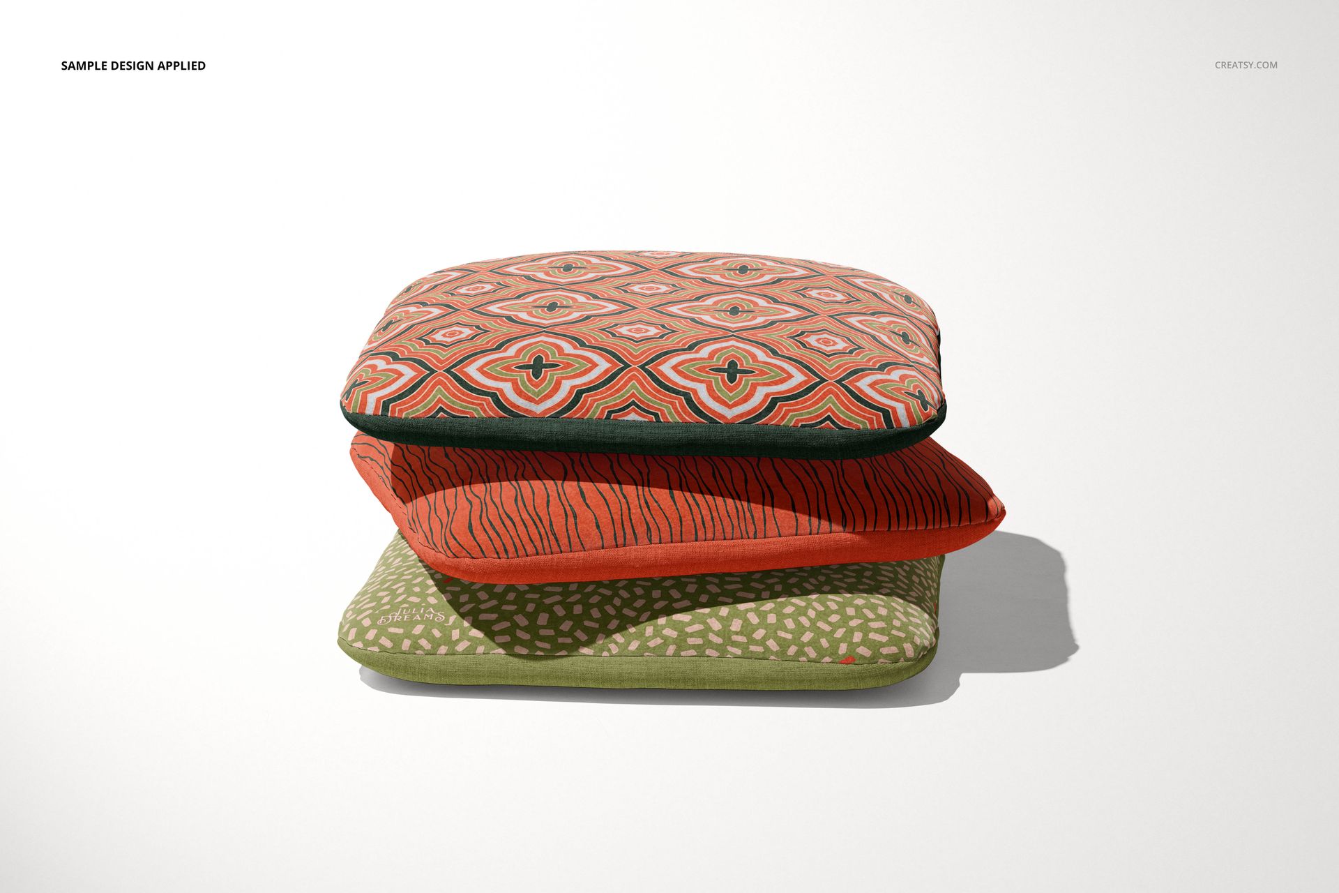 PSD mockup featuring a trio of decorative chair cushions with distinct designs, displayed against a neutral backdrop.