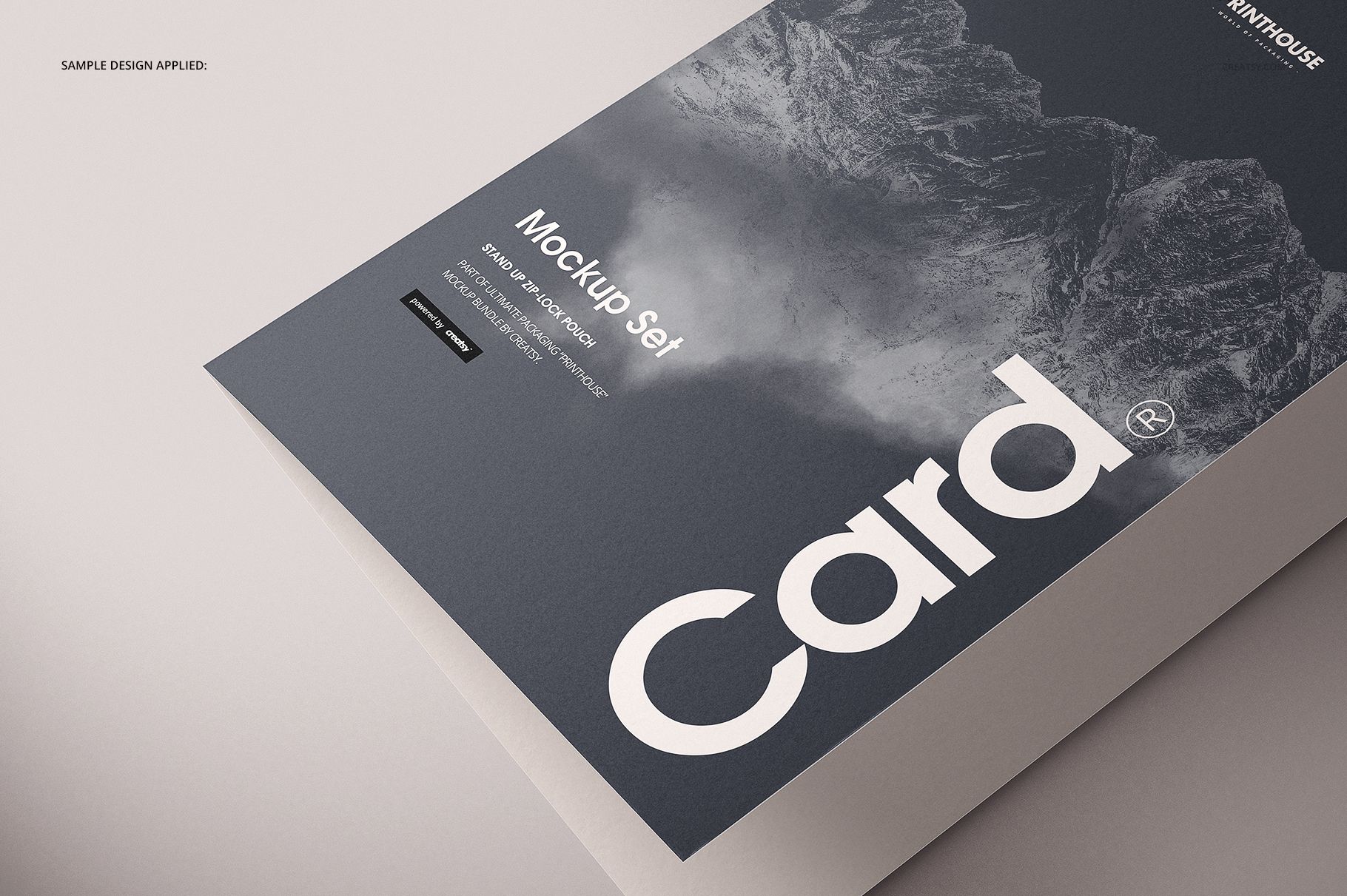 Folded A4 card mockup shown from a close side angle, featuring a dark mountain design and bold white text.