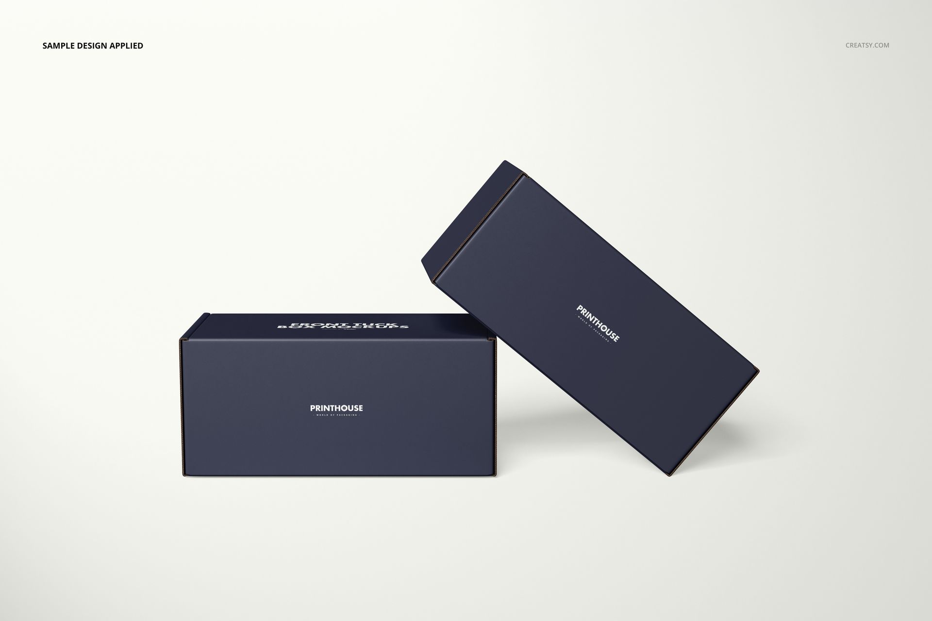 PSD mockup showing two dark blue packaging boxes with minimal white branding, arranged on a light surface.