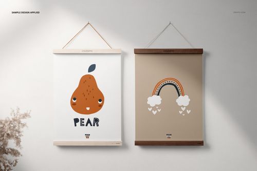 Wooden poster hanger PSD mockup featuring a pair of prints, one with a fruit graphic and one with a rainbow, against a neutral wall.