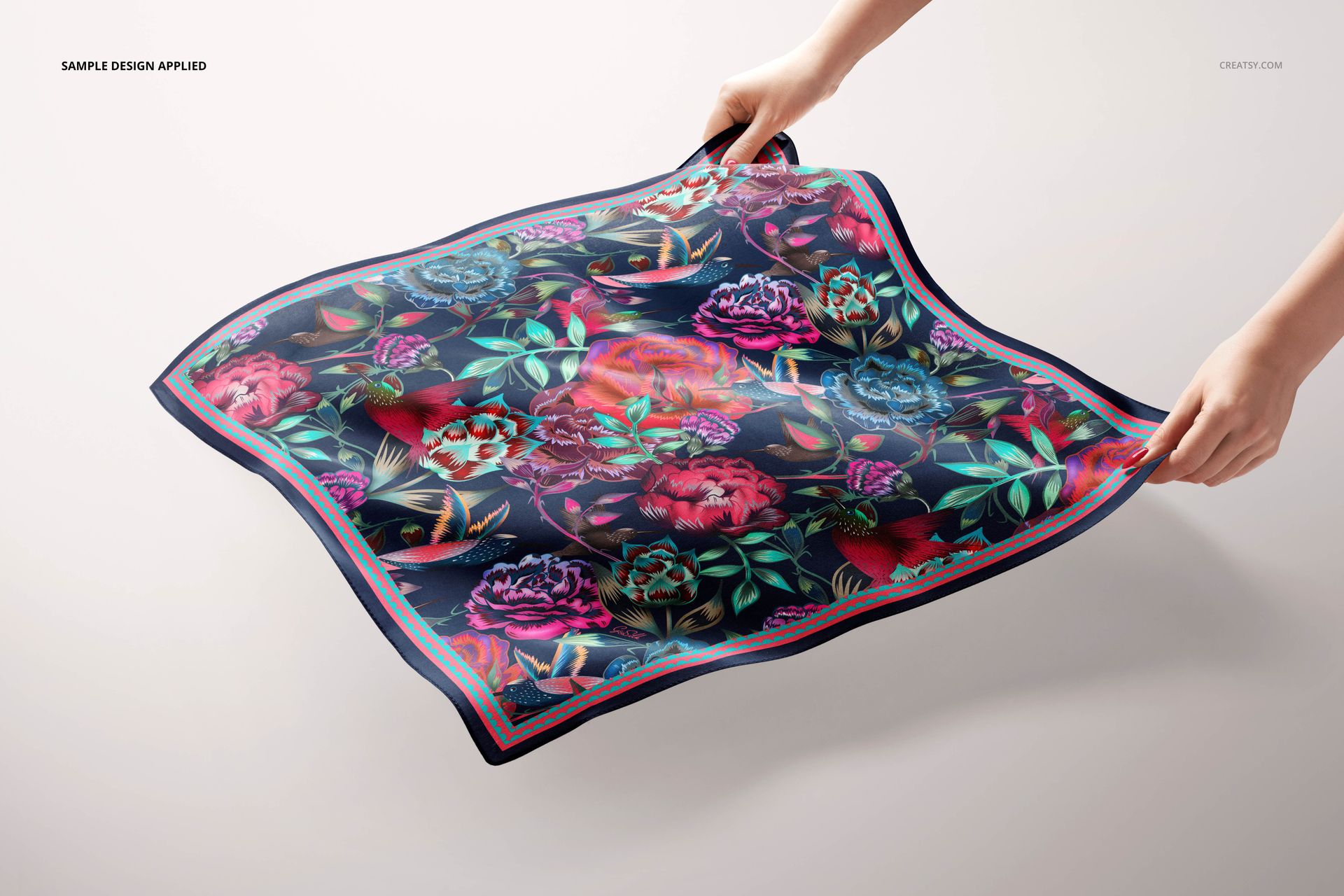 Colorful flower-printed square silk scarf mockup being stretched by hands, shown against a plain light surface.