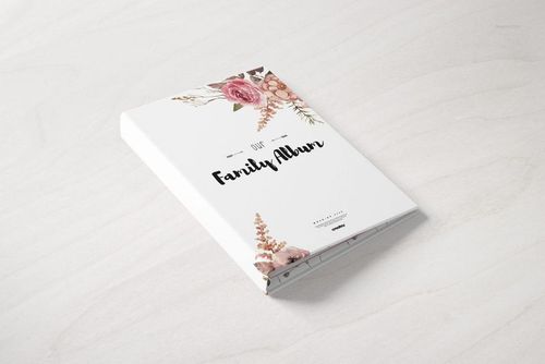 Hardcover family book mockup with white cover, floral illustration, and black text, shown from angled top view.