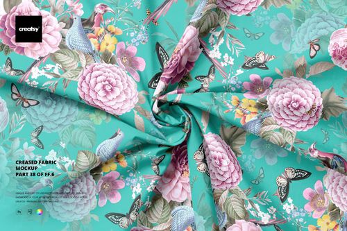 Creased cotton fabric with a turquoise background featuring pink flowers, birds, and butterflies in a top view mockup scene.