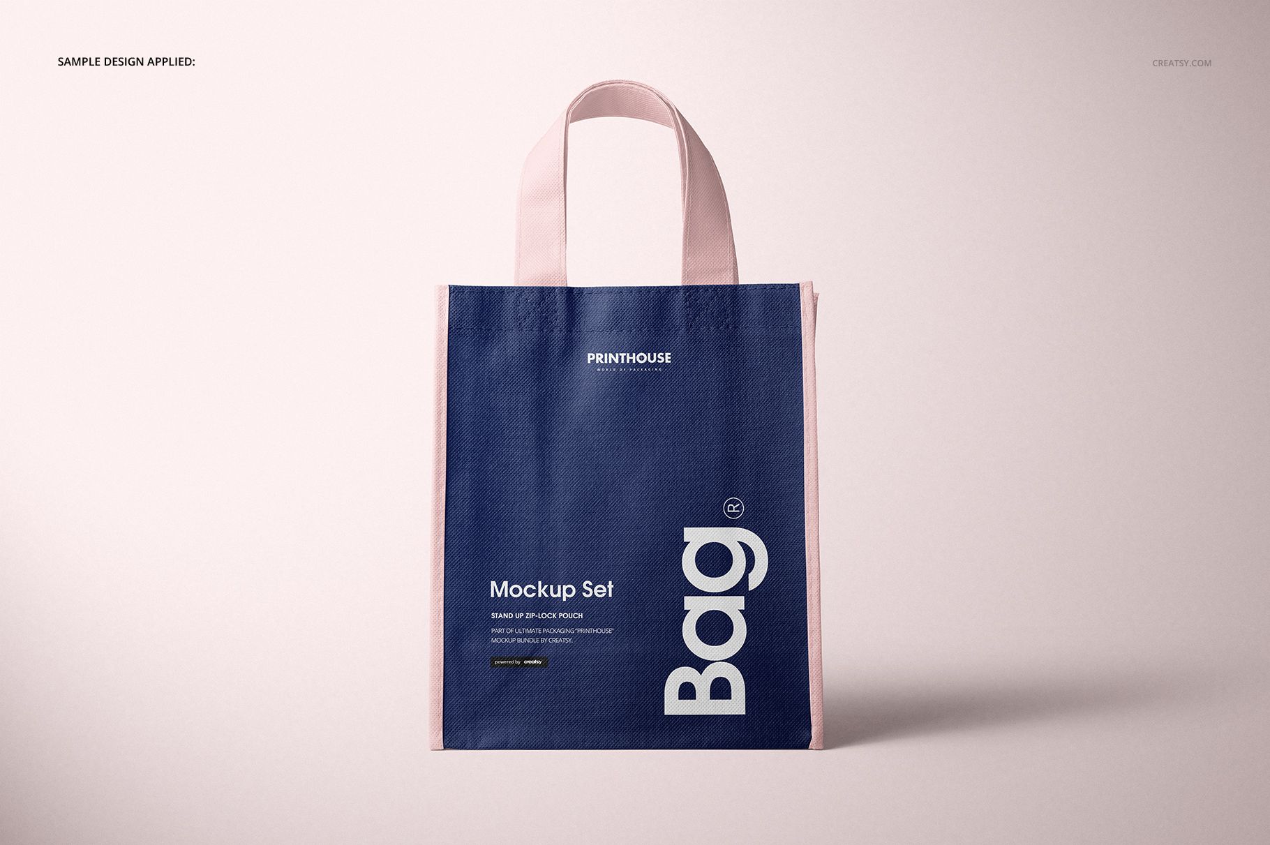 Non-woven tote bag mockup displayed upright, showing a navy blue front and light pink trim against a neutral backdrop.
