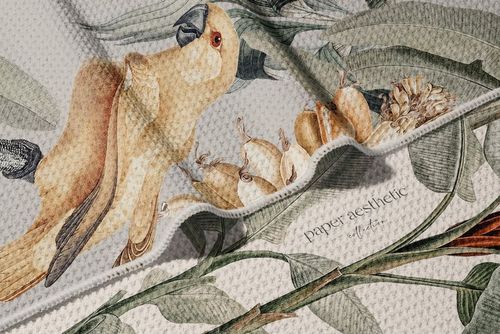 Close-up of a waffle beach towel mockup with a parrot and botanical pattern, highlighting woven texture and folds.
