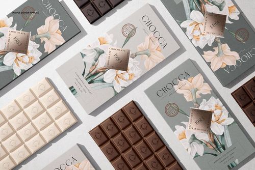 Assorted chocolate bar packaging mockups displayed in a flat lay, featuring floral designs and various chocolate colors.