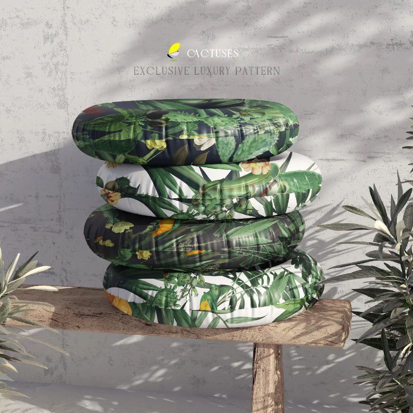 Swim ring mockup featuring four inflatable rings with tropical leaf patterns stacked on a wooden bench, set outdoors.