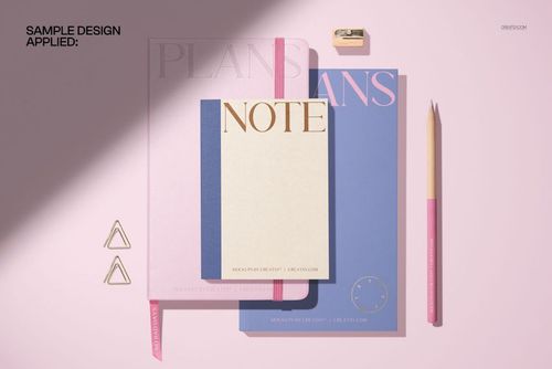 Stationery PSD mockup featuring a leather calendar, notebooks, pencil, clips, and sharpener in soft lighting.