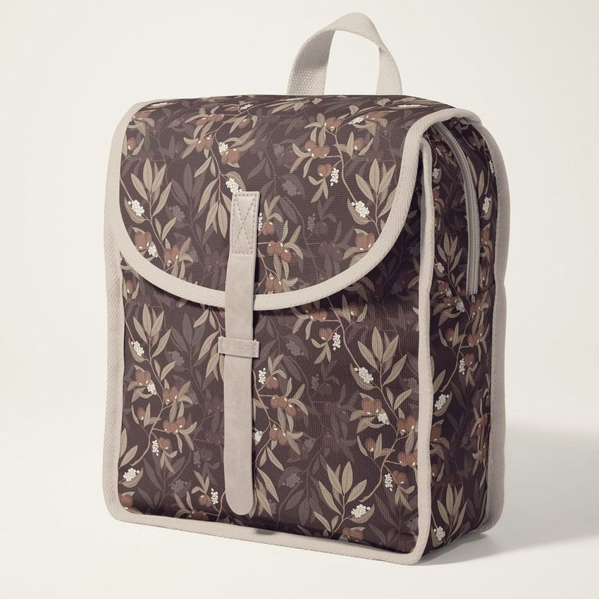 Kids backpack mockup featuring a botanical olive branch pattern in earthy tones, photographed on a light neutral background.